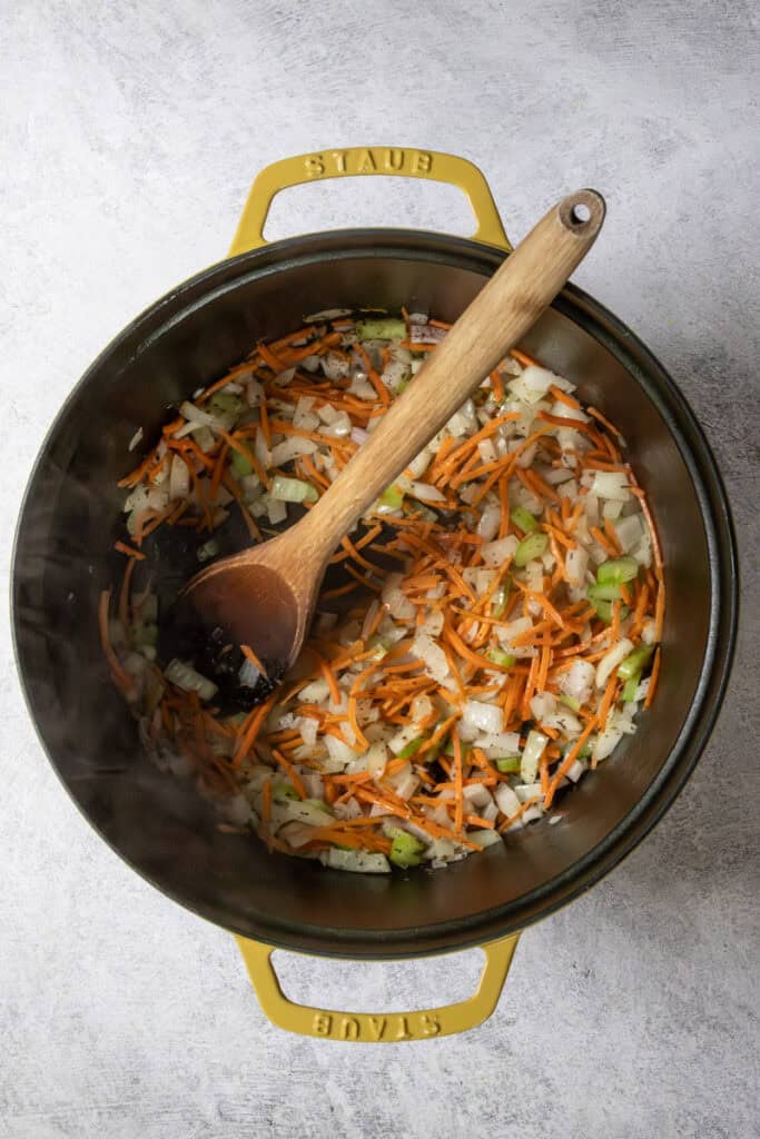 Chopped carrot, onion, celery and herbs in skillet.