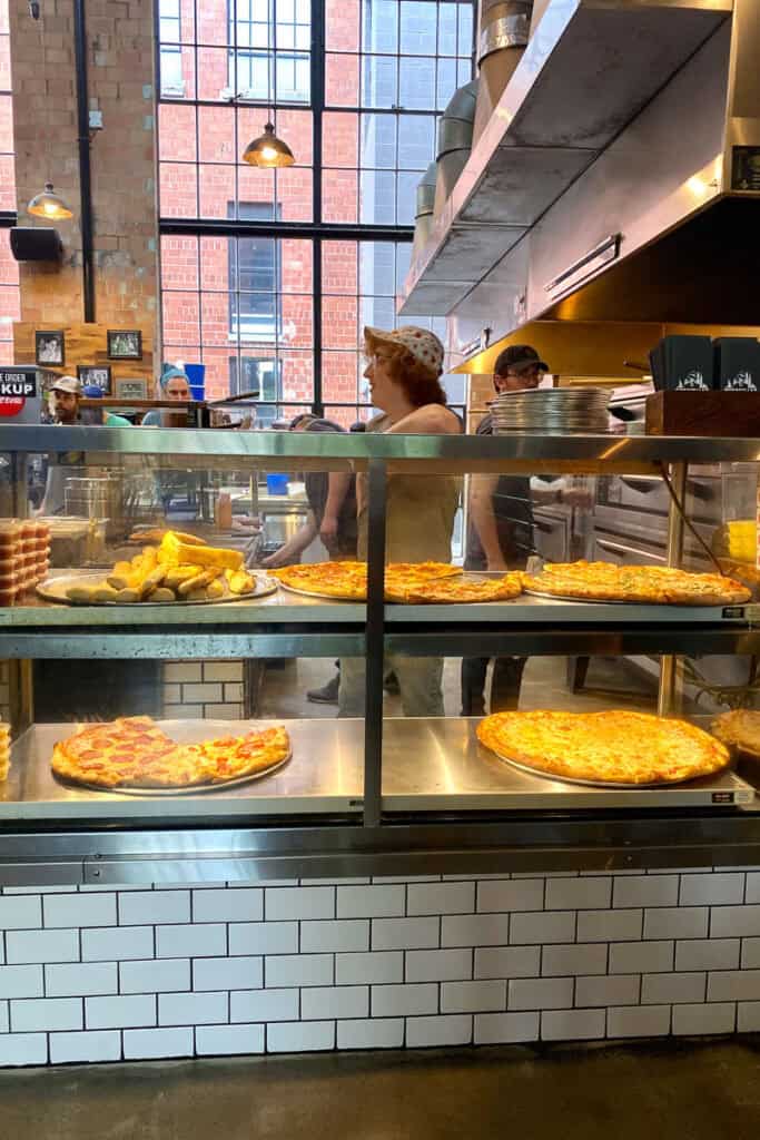 Pizzas in display case.