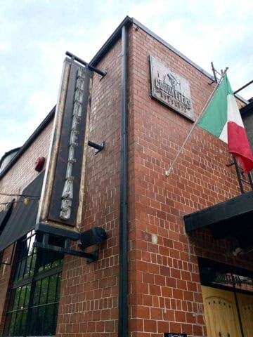 Sign for Goodfellas bolted to outside of brick building.