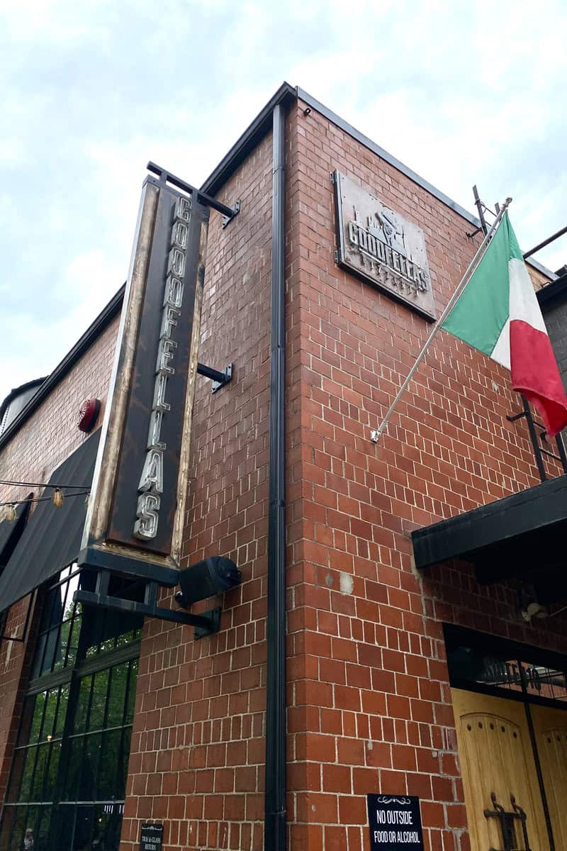 Sign for Goodfellas bolted to outside of brick building.