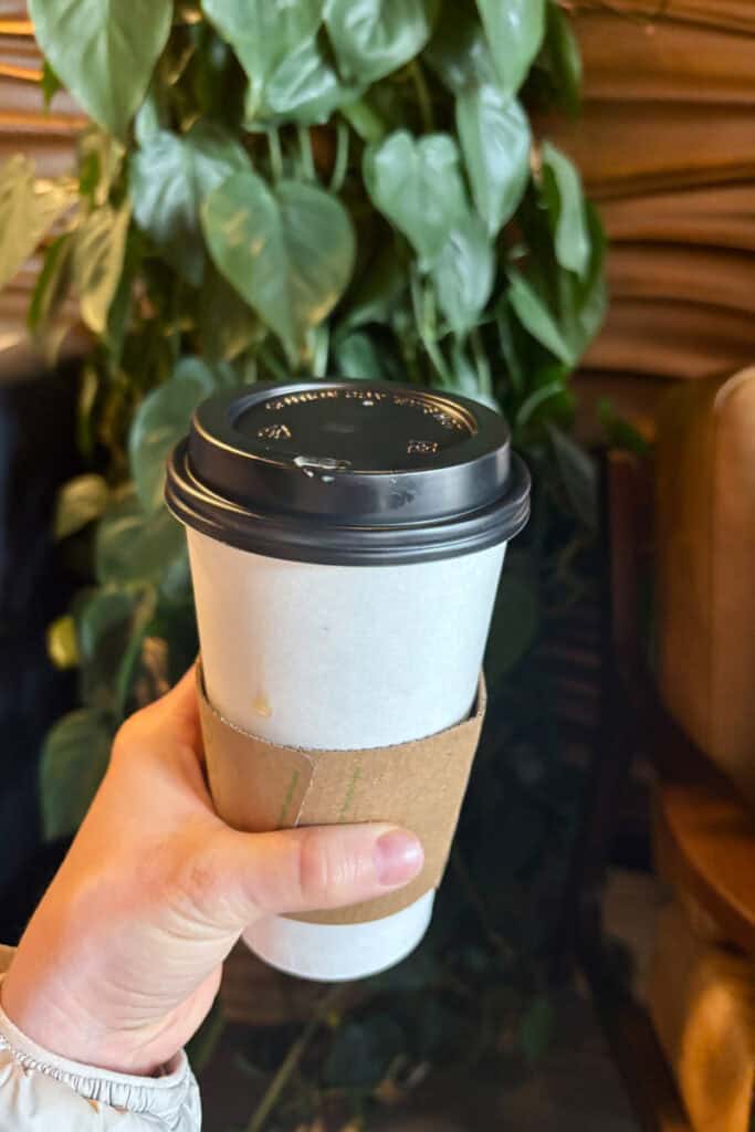 Coffee drink in disposable cup at The Greenery Coffee Shop.