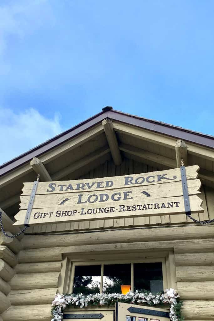 Sign for Starved Rock Lodge above log cabin style building.