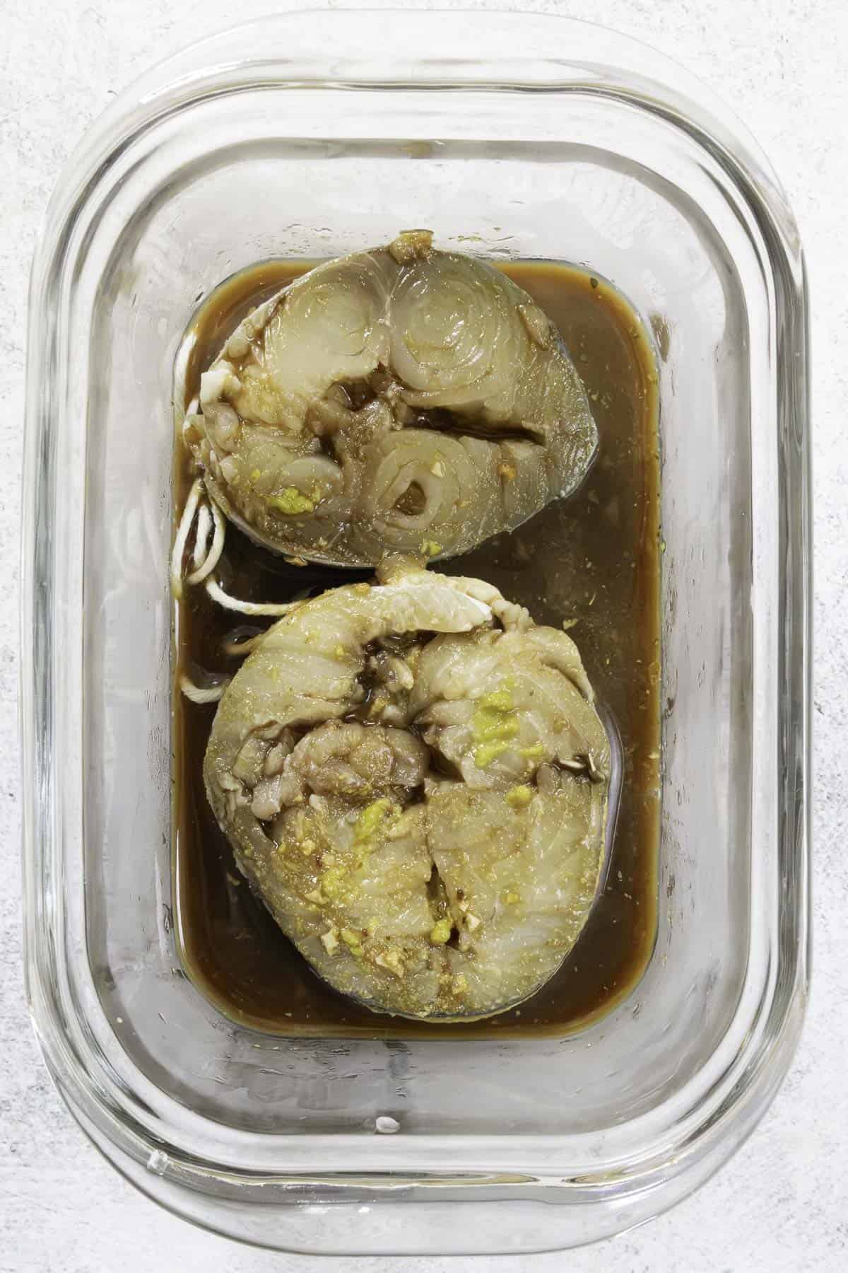 marinating mackerel steaks in a glass dish.