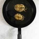 broiled mackerel steaks on a black skillet.