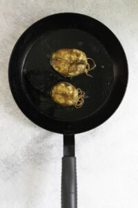 broiled mackerel steaks on a black skillet.