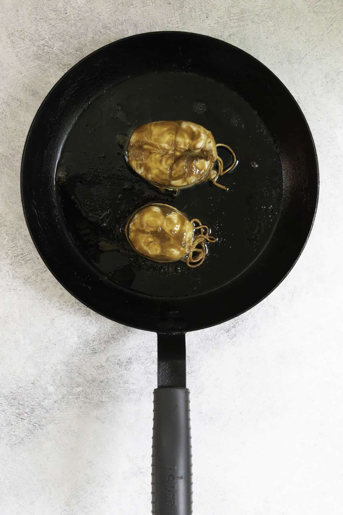 broiled mackerel steaks on a black skillet.
