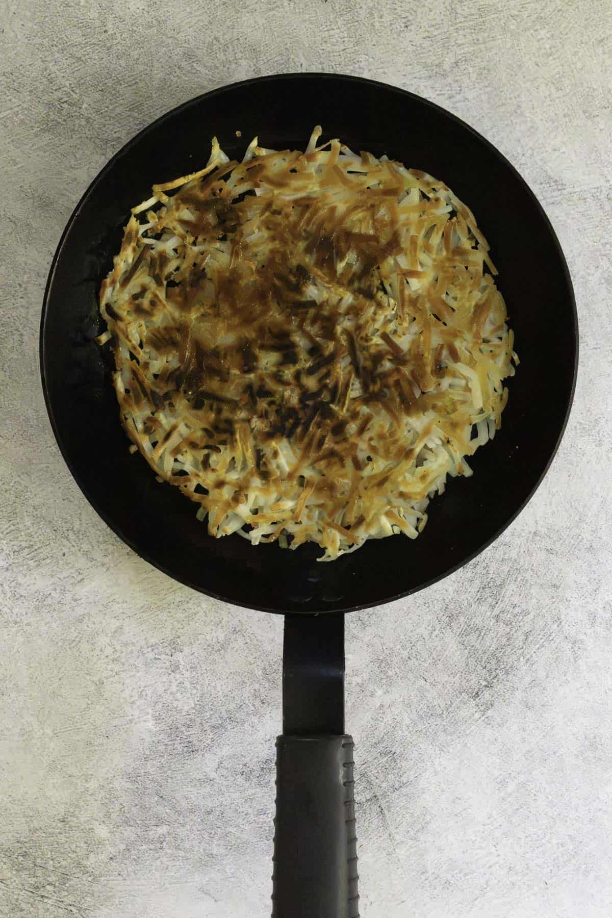 flipped potato pancake back in pan.