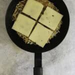 slices of raclette cheese on top of potato pancake.