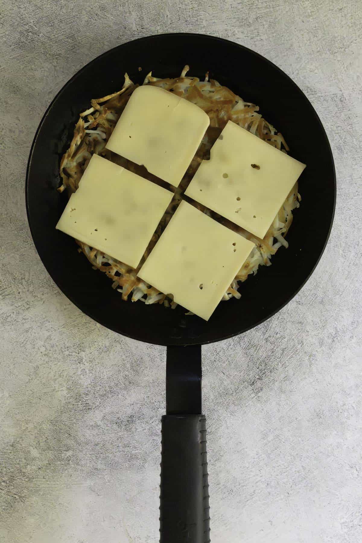 slices of raclette cheese on top of potato pancake.