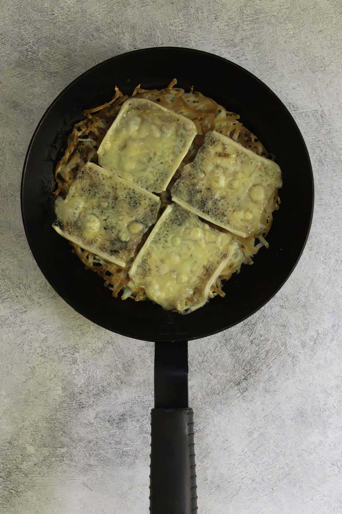 melted raclette cheese on potato pancake.