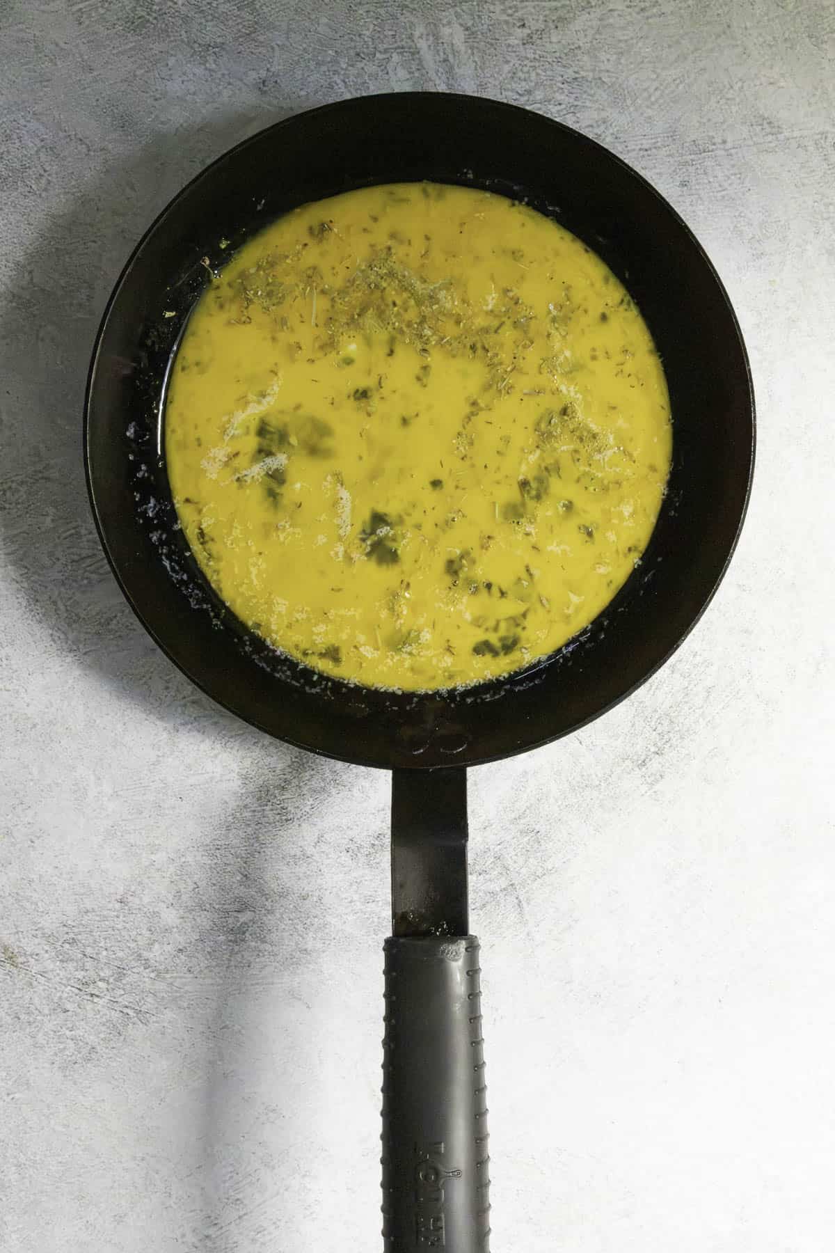 whipped eggs in omelette pan.