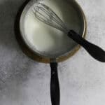 Milk and whisk in saucepan.