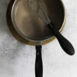 Hot chocolate mix stirred into warm milk in saucepan.