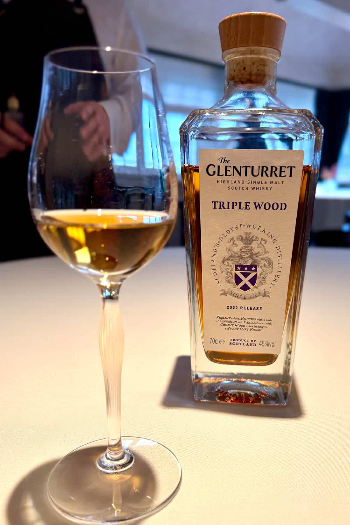 Bottle of Glenturret single malt whiskey and wine glass with a small amount in it.